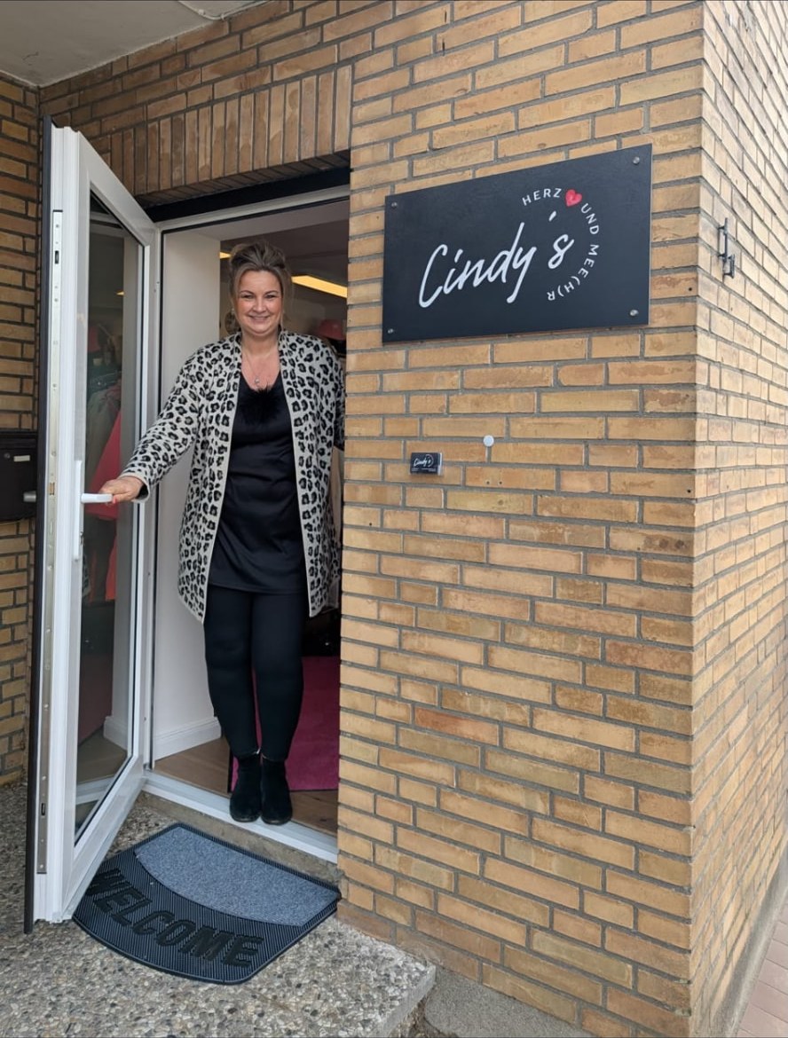 Cindy Preuß-Grutke begrüßt Gäste in der offenen Ladentür ihrer Boutique in Osdorf